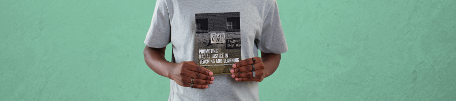 A student holds up a journal entitled "Promoting Racial Justice in Teaching and Learning"